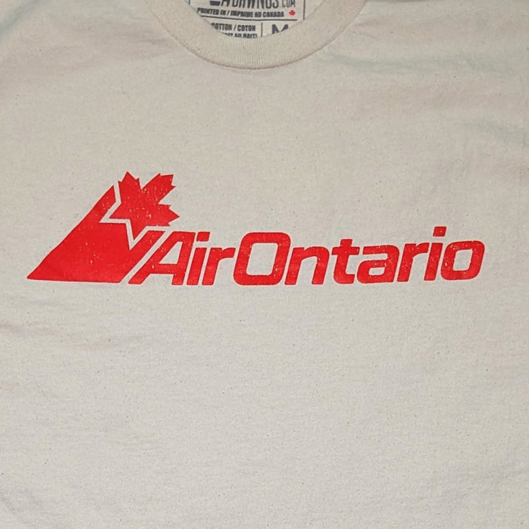 A close-up of a vintage off-white t-shirt featuring the red AirOntario logo printed across the chest.
