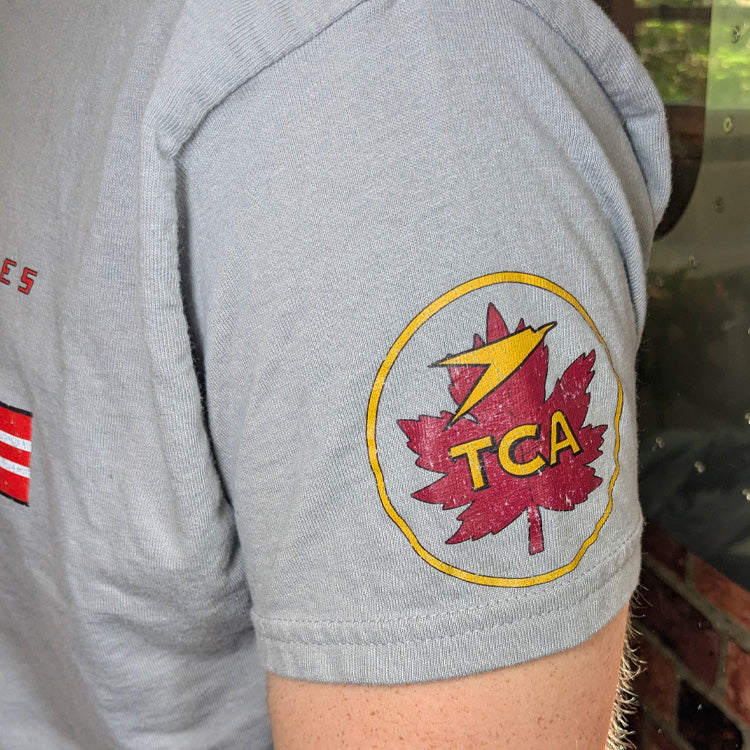 A close-up of a gray t-shirt featuring a distressed red and yellow Trans-Canada Air Lines graphic on the arm