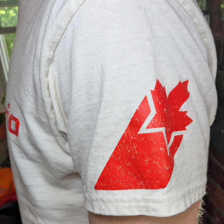 A close-up of a vintage off-white t-shirt featuring the red AirOntario logo printed across the arm.